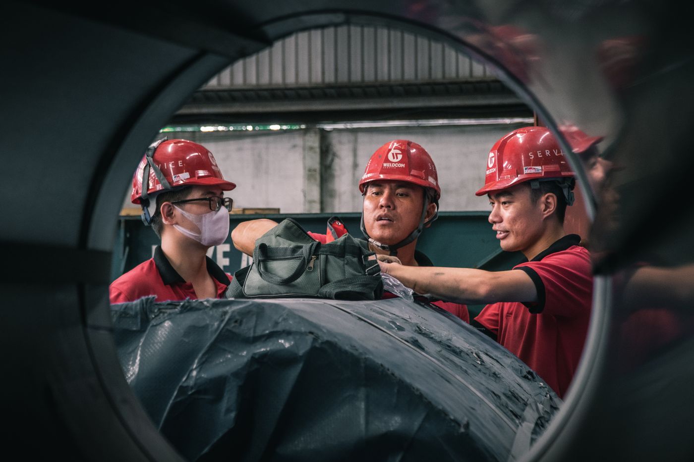 Profesionales con cascos en una instalación industrial; fotografía referencial